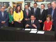 Florida Governor DeSantis signing a bill at a Honda dealership