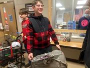 Chaffee Junior Senior High school student holding an automatic transmission to "Anything but a backpack" day