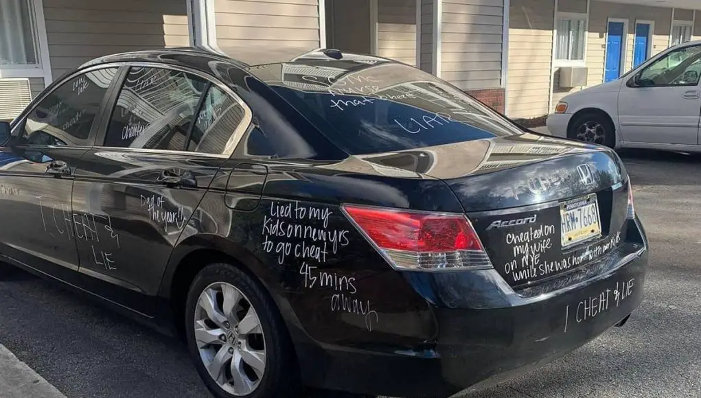A black Honda Accord defaced by wife finding out she was cheated on