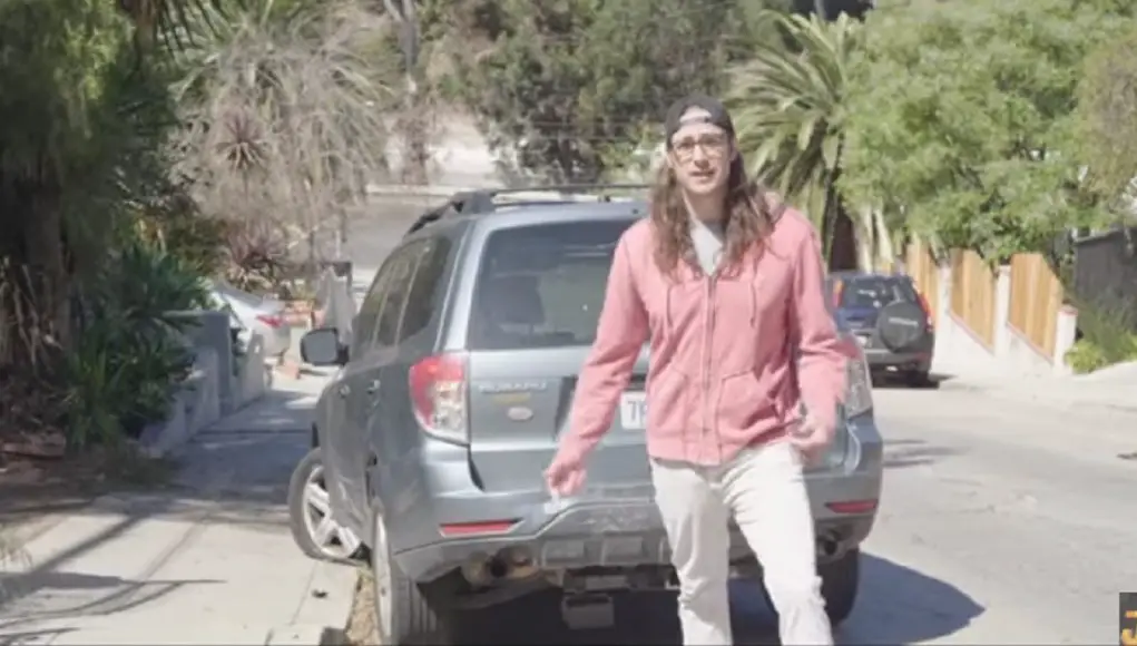 L.A. Musician Jordan Hook standing in front of his Subaru Forester damaged by that flying Tesla Model S from Alex Choi video