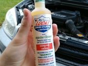 Lucas Oil Fuel Treatment held in front of a Toyota RAV-4