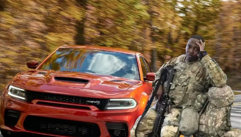 A Dodge Charger next to a US Soldier who looks peeved