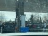 Customers at the Costco Gas station strech their hoses across their cars to reach the other side