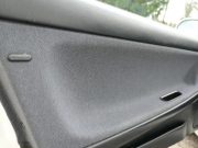 The door of a Mazda MX-3 with a conductive plastic button for dissipating static electricity
