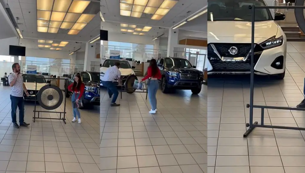 a new car owner kicks a celebratory gong into a new Nissan Maxima