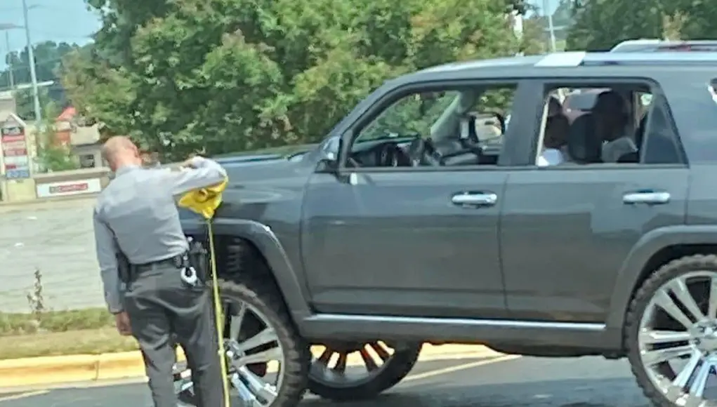 North Carolina State Highway Patrol office measuring the ride height on a Toyota in violation of the Carolina Squat law