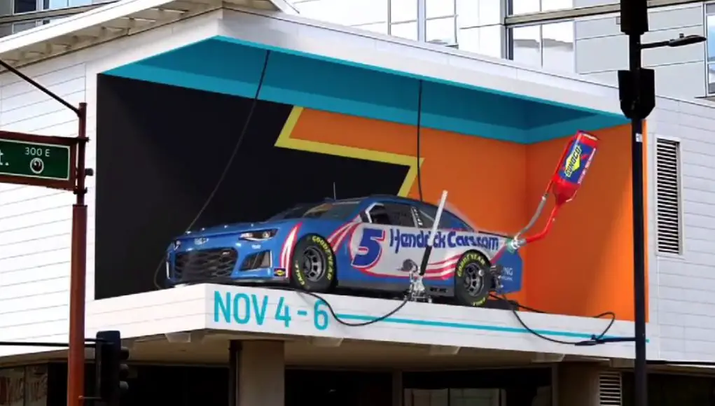 A 3D billboard ad for NASCAR showing a pit stop with one mistake, it's showing the old 5 lug wheel setup.