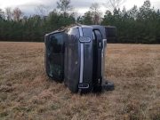 A Rivian R1T truck rolled on its side after driving on farmland