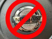 A rhinestone steering wheel emblem on a Nissan crossed out as a warning