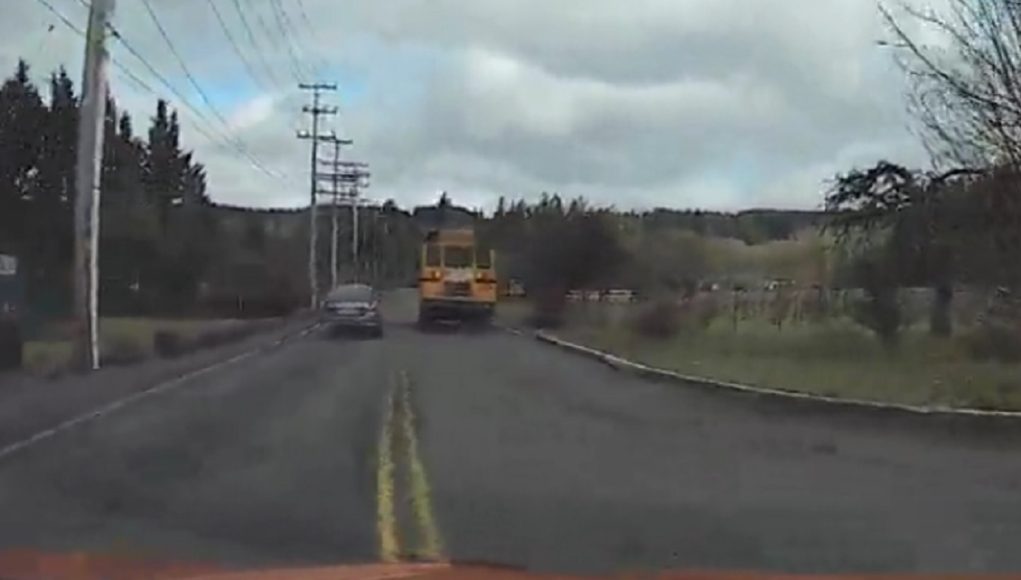 A car overtakes a school bus crossing double solid yellow lines in Battle Ground WA