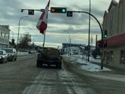 Canadian flag mounted in the back of a dually is too tall for traffic light.