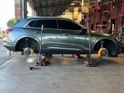 A car lifted off the ground using just floor jacks.