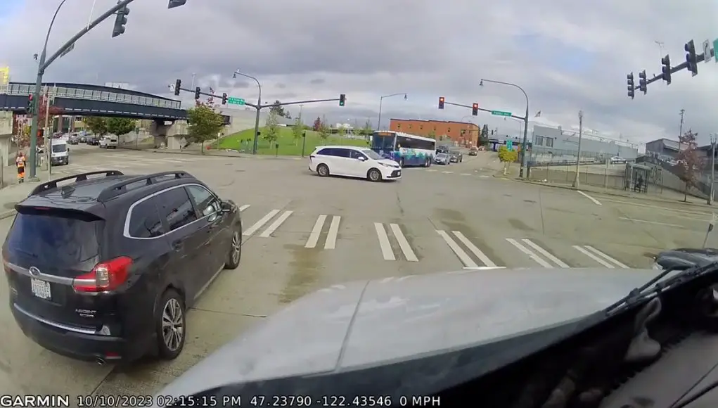 Elderly driver blows through red light in Tacoma several seconds after turning red.