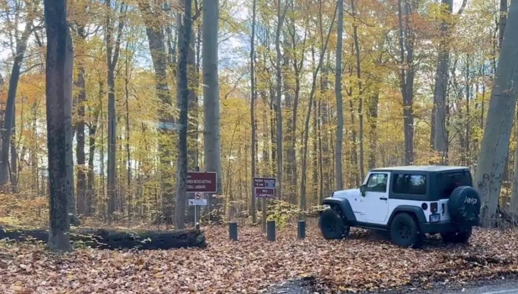 A Jeep driving onto Warren Woods Hiking Trail.