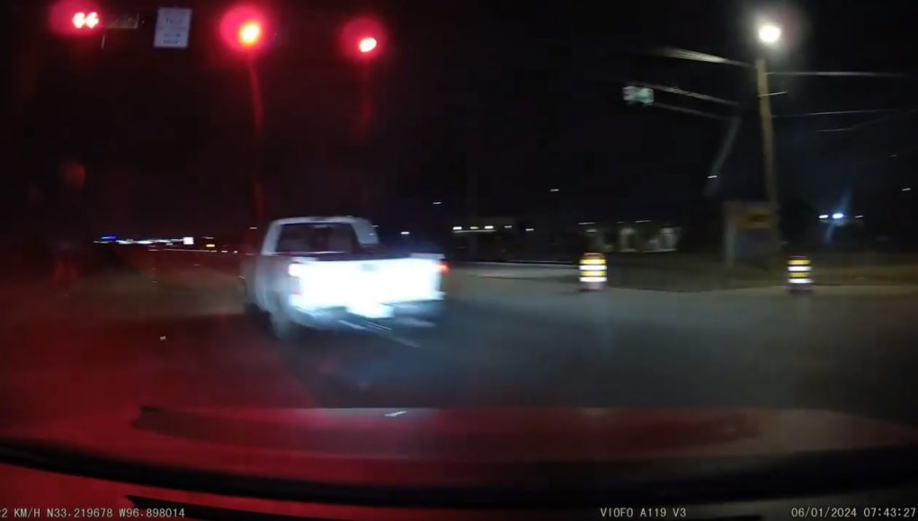 Driver fleeing policein Aubrey, TX runs red light and narrowly avoids hitting driver legally turning left.