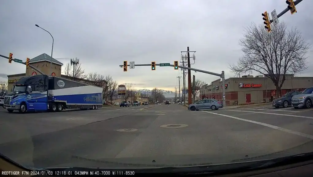 Corolla driver wearing headphones does a no-look right turn on red.