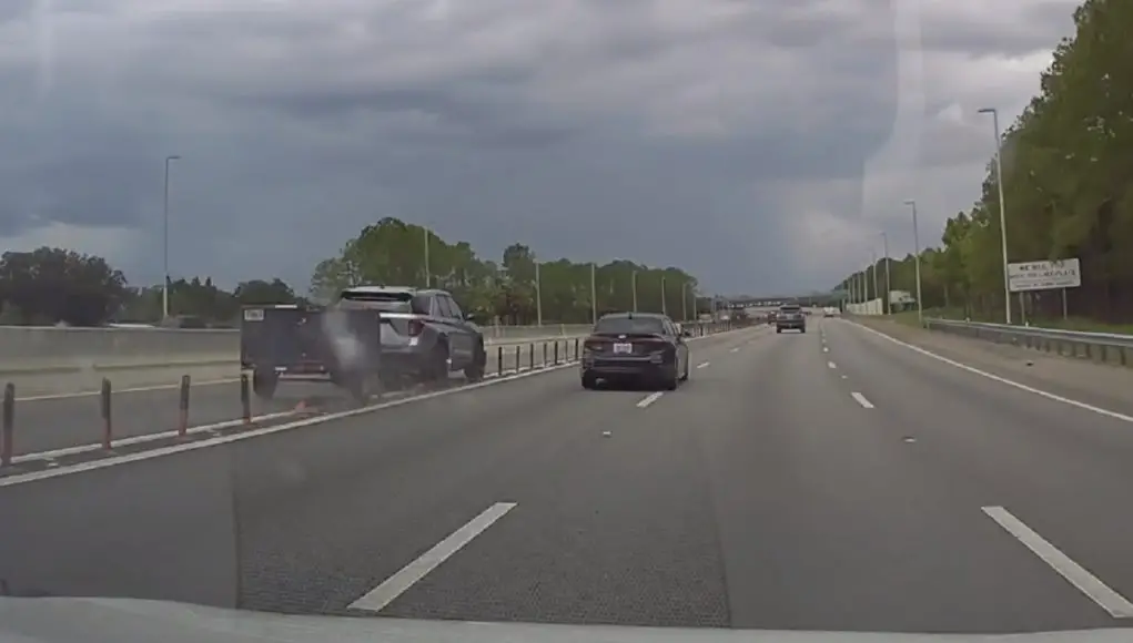Trailer-towing SUV runs over lane seperators causing windshield damage to this driver in Tampa, FL