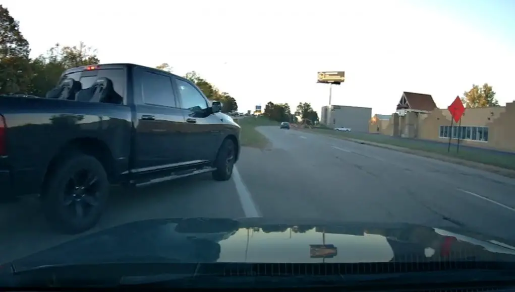 A driver in a black Ram 1500 attempts to use an on-ramp as on off-ramp. Nearly causes collision with dashcam owner.