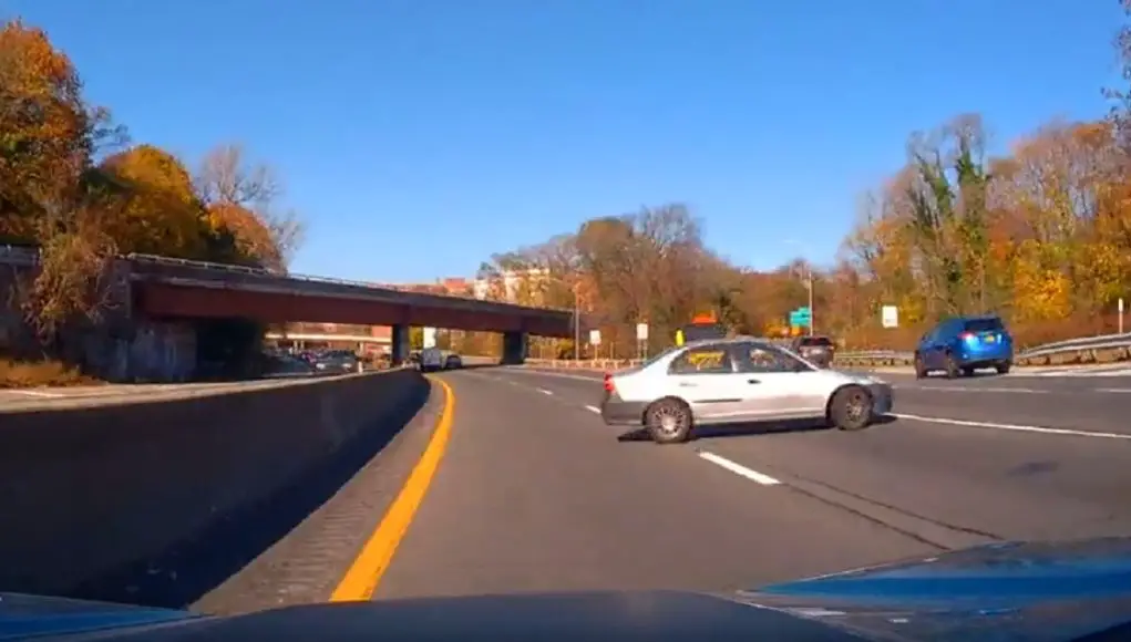 Driver on Bronx River Parkway makes u-turn and drives against traffic to avoid missing their exit.