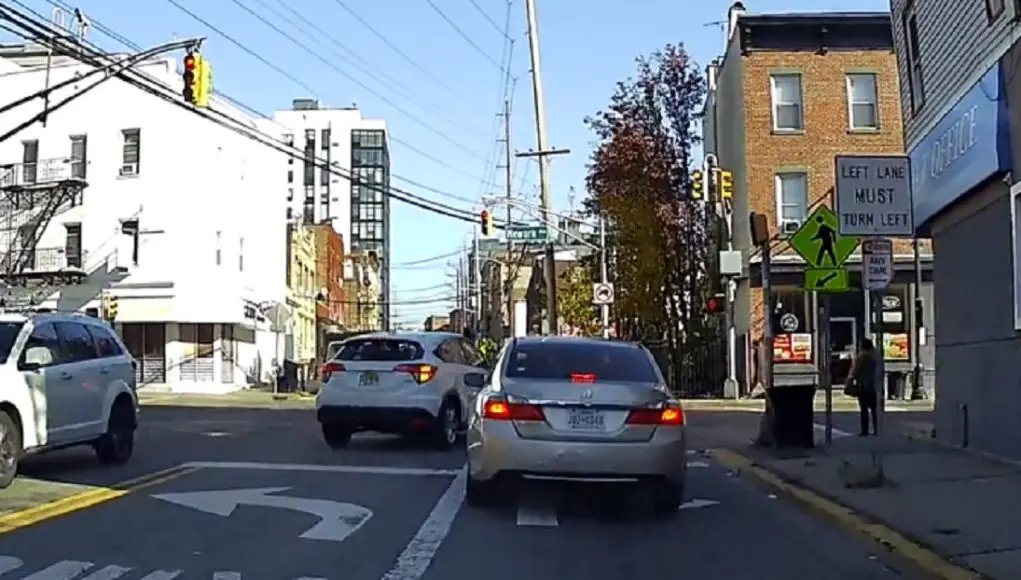 Driver in Jersey City makes right turn using left turn only lane and almost takes out a pedestrian in the process.