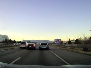 Dashcam captures driver on I-25 in Colorado Springs dangerously lane splitting between two vehicles in his Honda Civic.