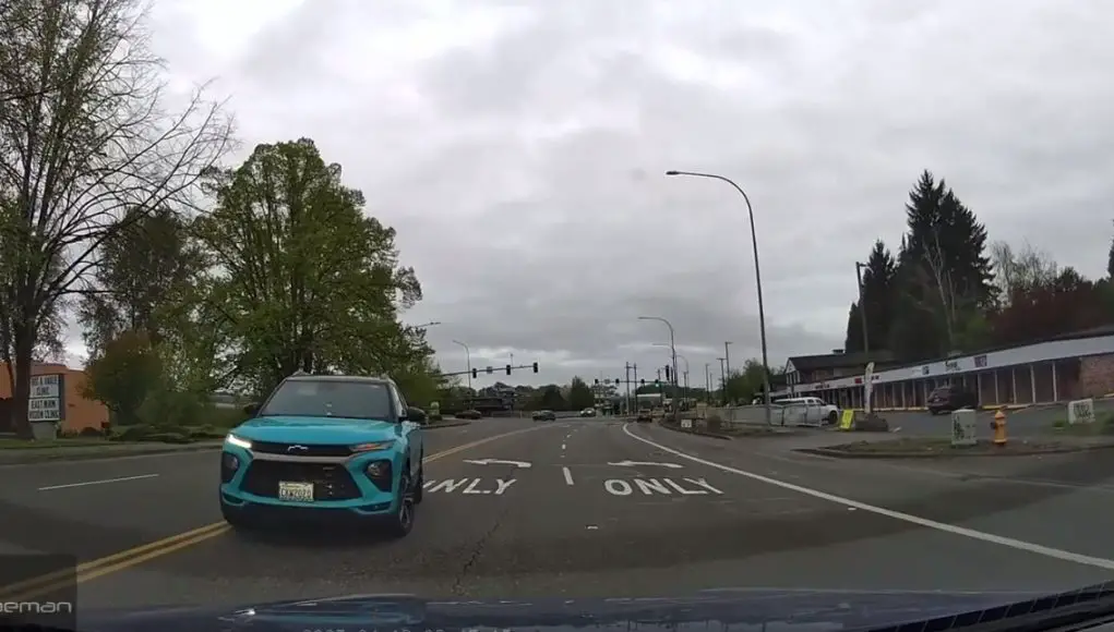 Idiot driver makes illegal left turn on E Main Ave across doube yellow lines and against traffic.