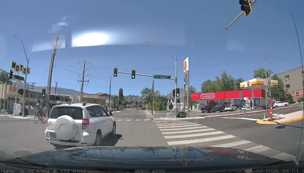 Ignorant driver on E 9th St. and Virginia pleads ignorance, does illegal lane change in the middle of the intersection.
