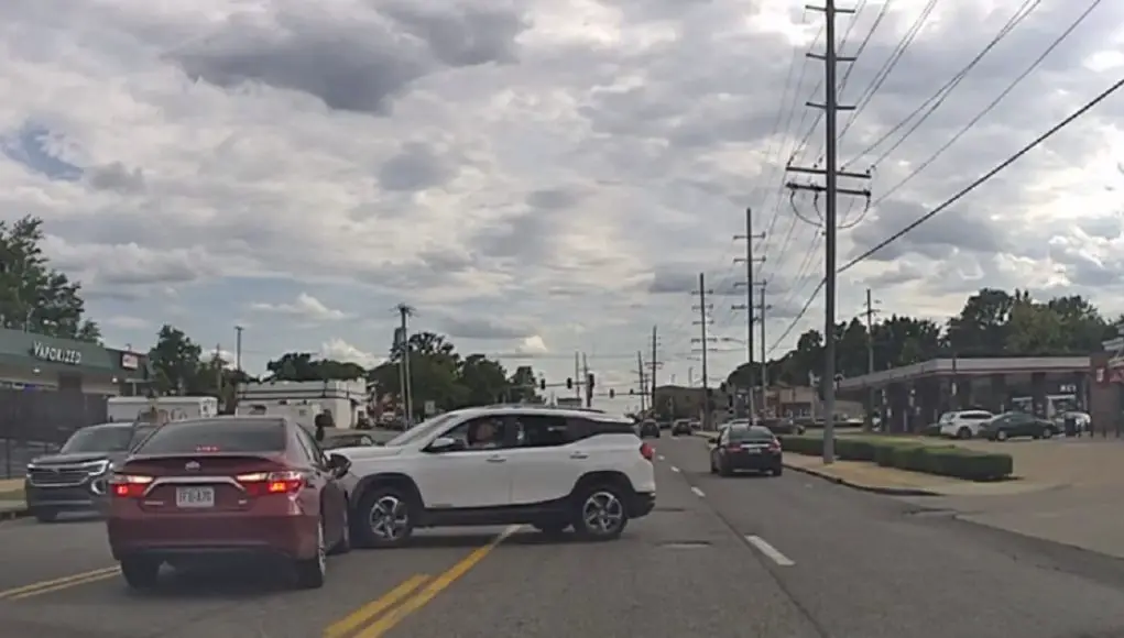 Driver turning left across stopped traffic fails to yield, gets hit by driver possibly illegally cruising down two-way-left-turn lane.