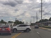 Driver turning left across stopped traffic fails to yield, gets hit by driver possibly illegally cruising down two-way-left-turn lane.