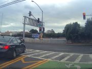 Driver at Pulgas and East Bay Shore pulls off insane move, driving against traffic and over double solid yellow to run red.