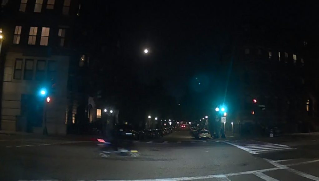 Scooter rider's late red run at Clarendon & Columbus causes driver to emergency brake.