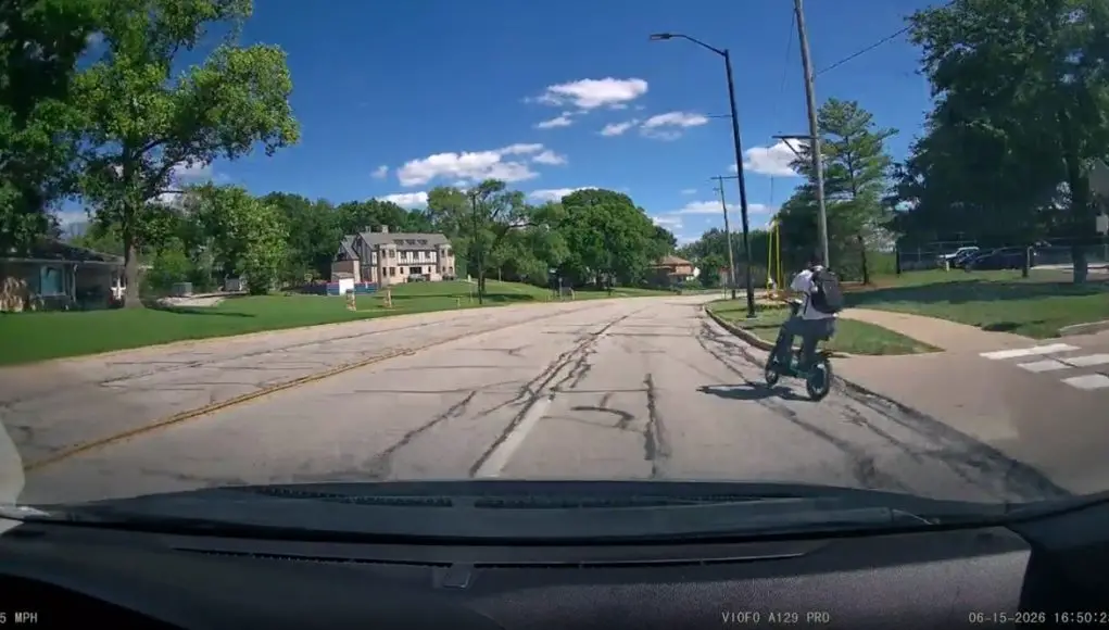 E-scooter rider's no look merge onto Northwestern Ave causes dashcam owner to swerve out the way.