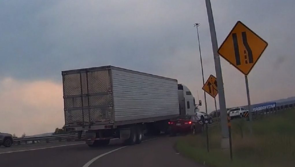 Goofball tries to pass semi on I-70 on-ramp using emergency shoulder. Gets side mirror ripped.
