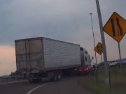 Goofball tries to pass semi on I-70 on-ramp using emergency shoulder. Gets side mirror ripped.