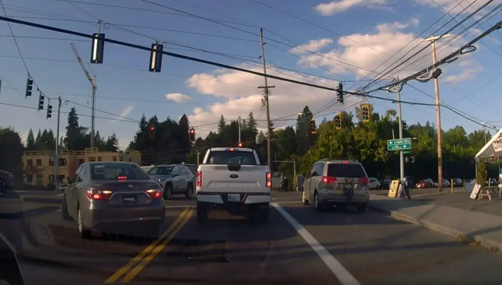 Confused driver on 19th Ave turning onto Barbur changes lanes into opposing traffic before realizing their mistake and reversing.